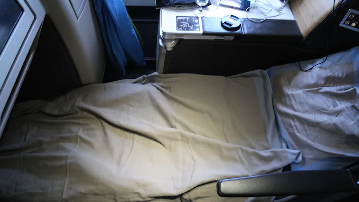 Business class seat in its lie-flat bed position