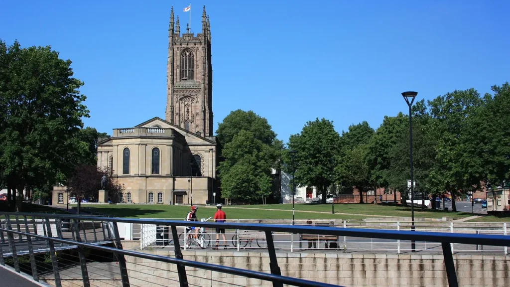 Derby Cathedral's Gothic tower and the riverside path on a sunny day