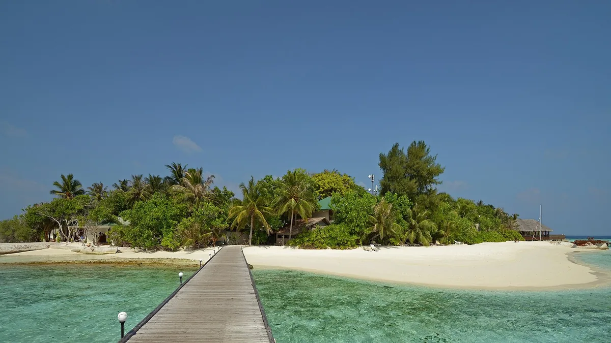 Resort island with a beach and jetty in the Maldives