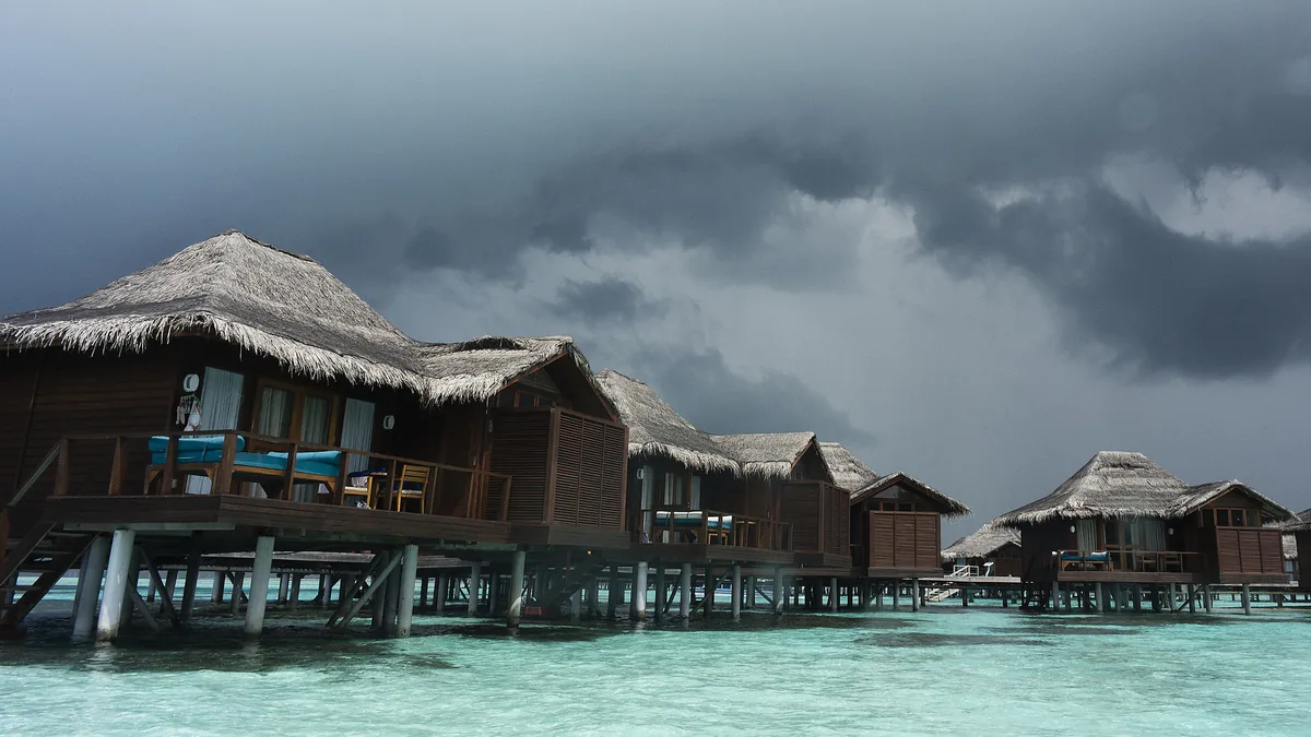Storm clouds over overwater villas in the Maldives