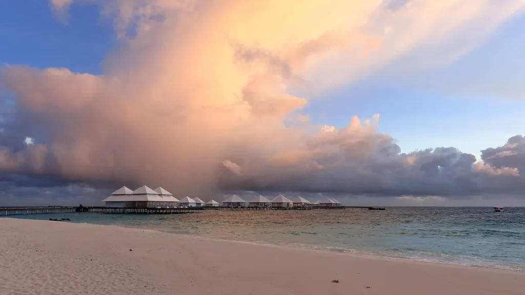 Villas on a Maldives island under a pink evening sky