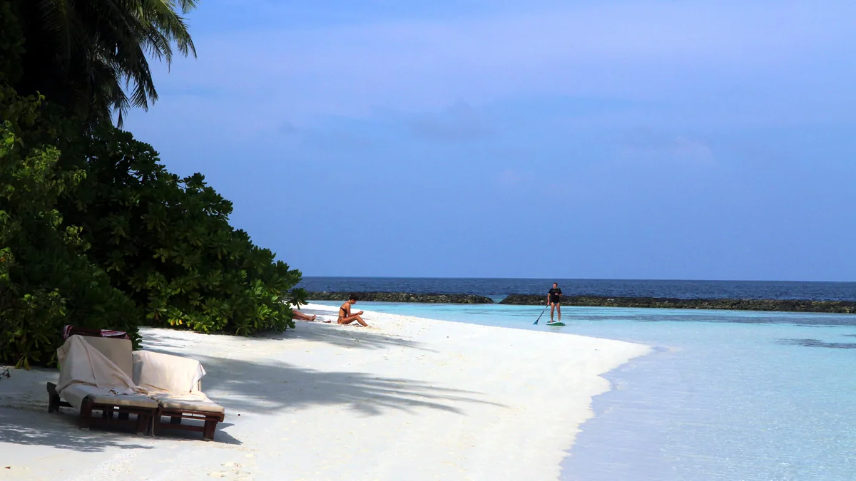 White sand beach under a clear blue sky in the Maldives