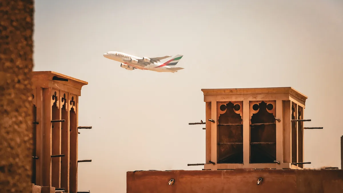 Wind towers in Al Fahidi Historical Neighbourhood, Dubai, with an aircraft overhead